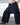 Person wearing a dark blue wide-leg pants with a quilted design on a neutral background