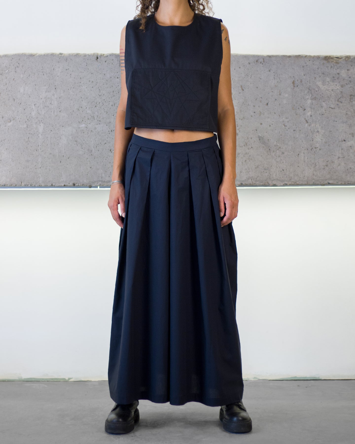Person wearing a black sleeveless top and long pants
